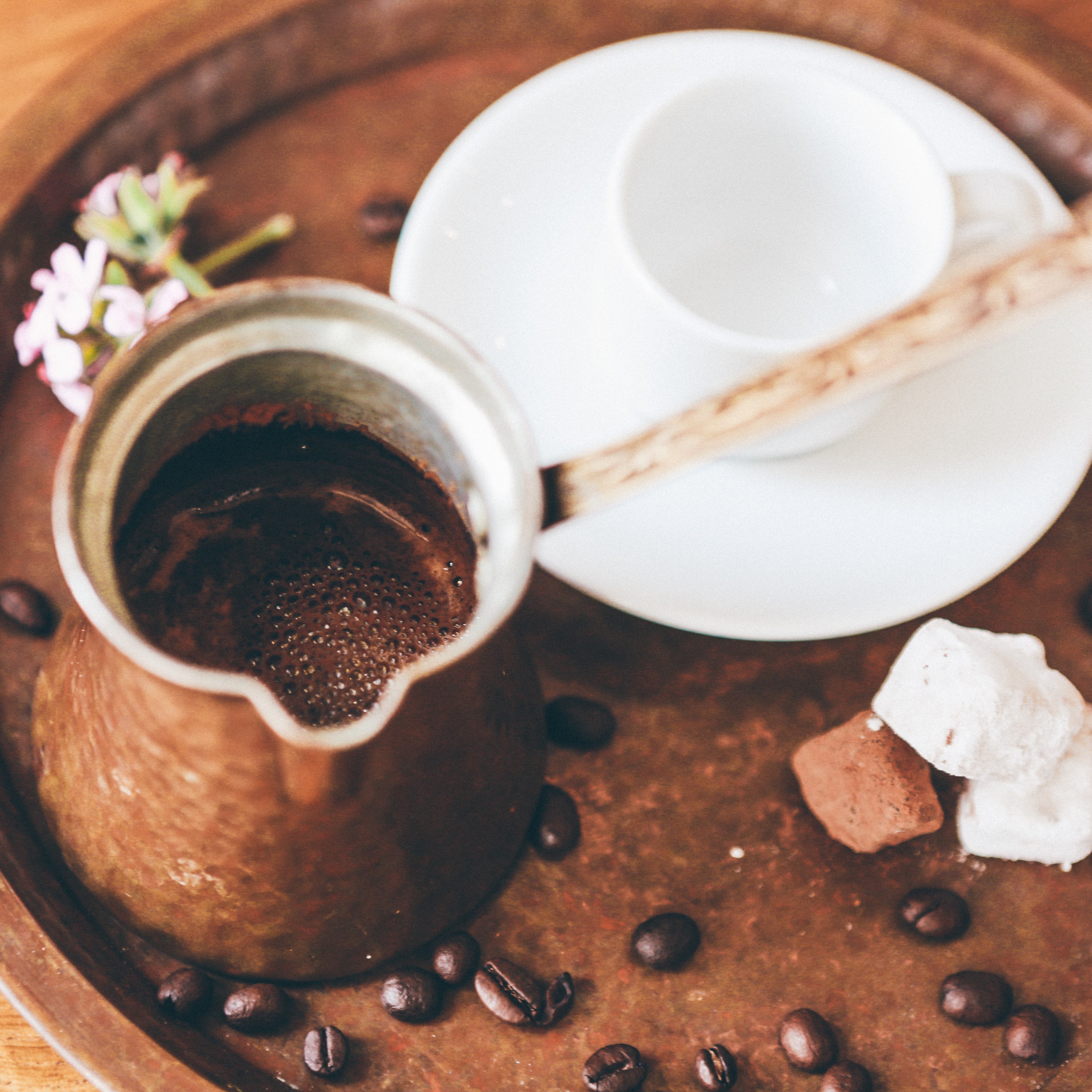 Cup of Greek Coffee served in a traditional greek coffee container